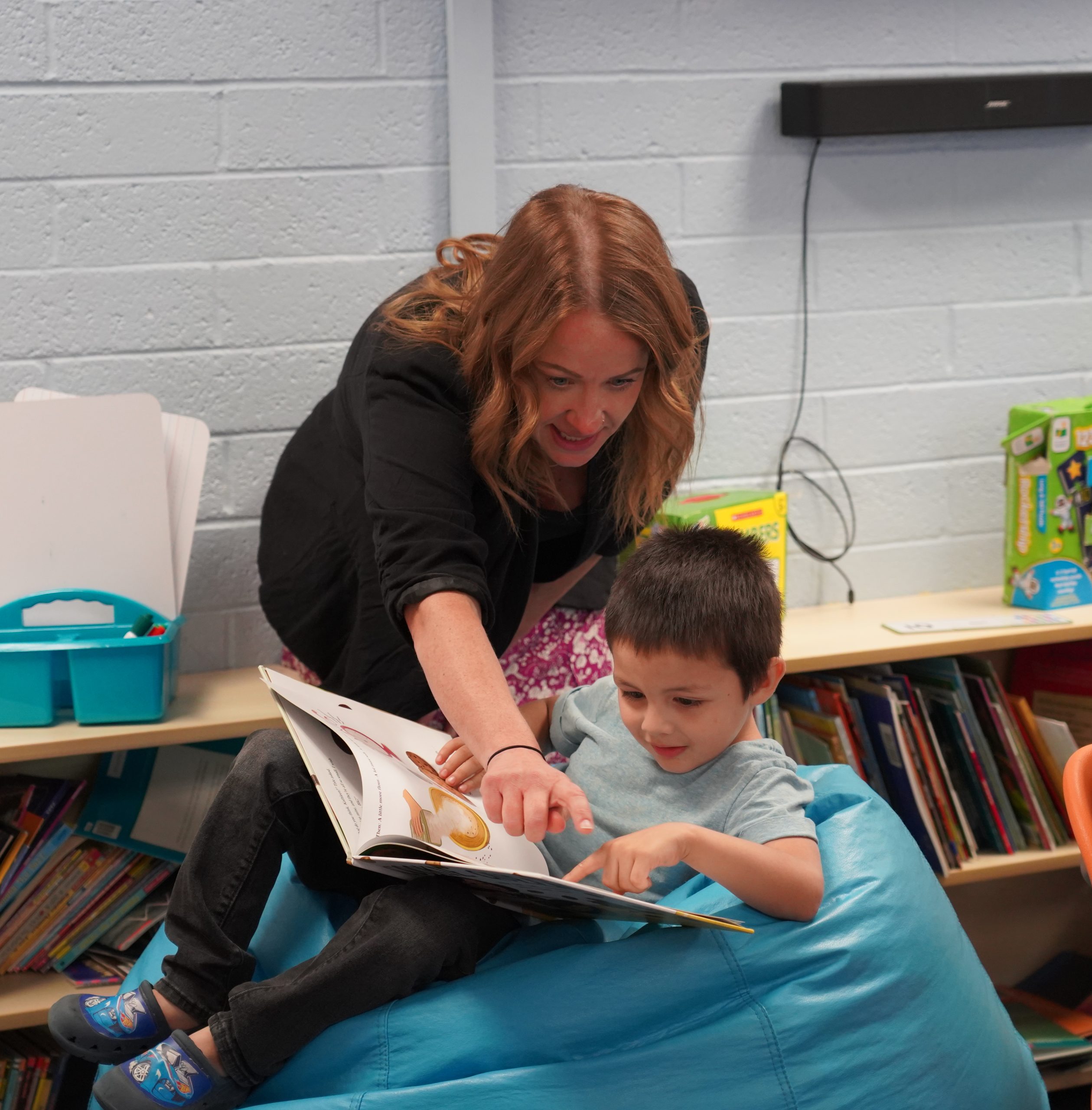 child reading with teacher