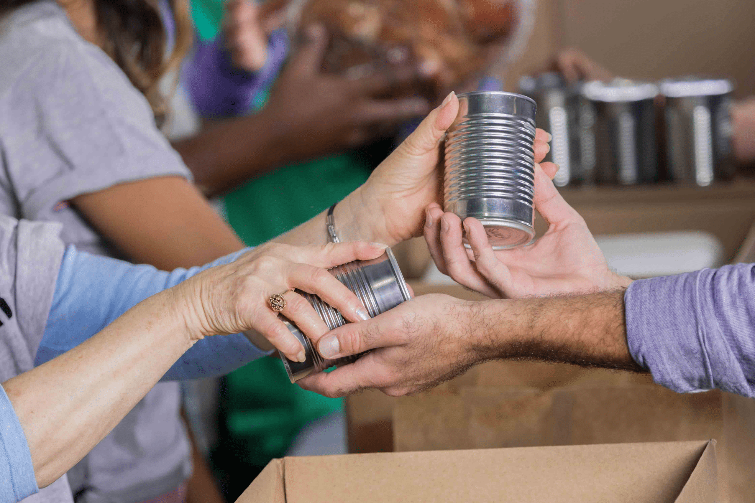hands passing a canned good