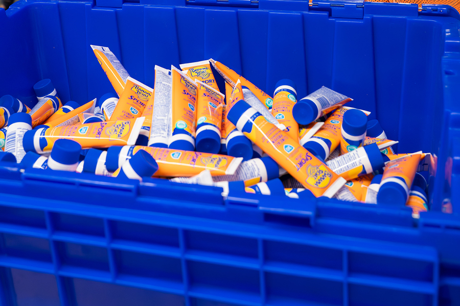 a bin containing multiple travel-sized sunscreen tubes